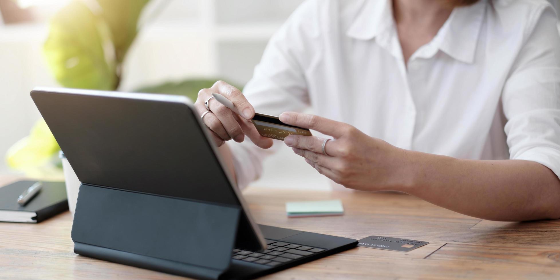 la ragazza fa un acquisto su internet al computer con carta di credito foto