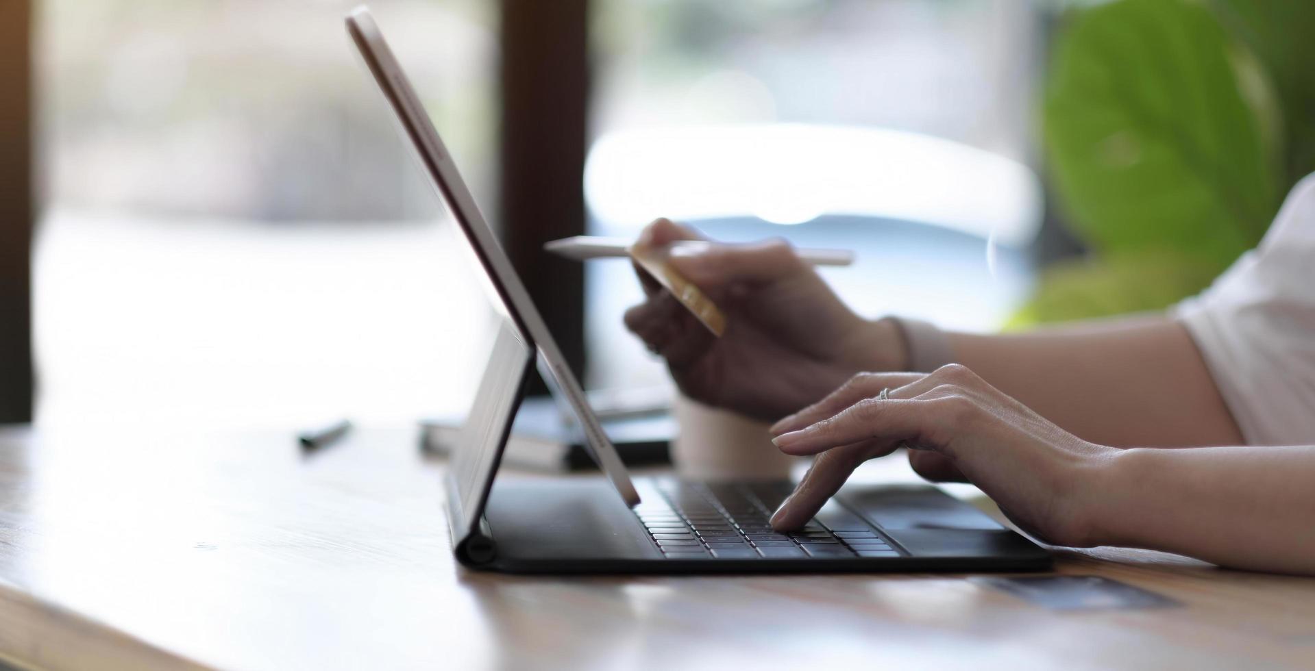 donna che utilizza laptop con calcolatrice e carta di credito sul tavolo, shopping online foto