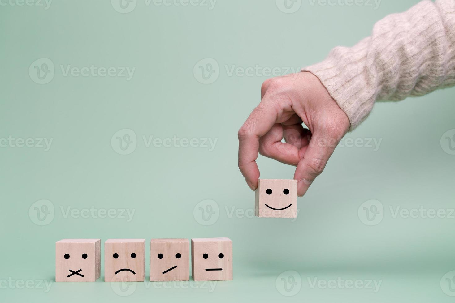 la mano del cliente sceglie una faccia felice. servizio, sondaggio, concetto di comunicazione tariffaria foto