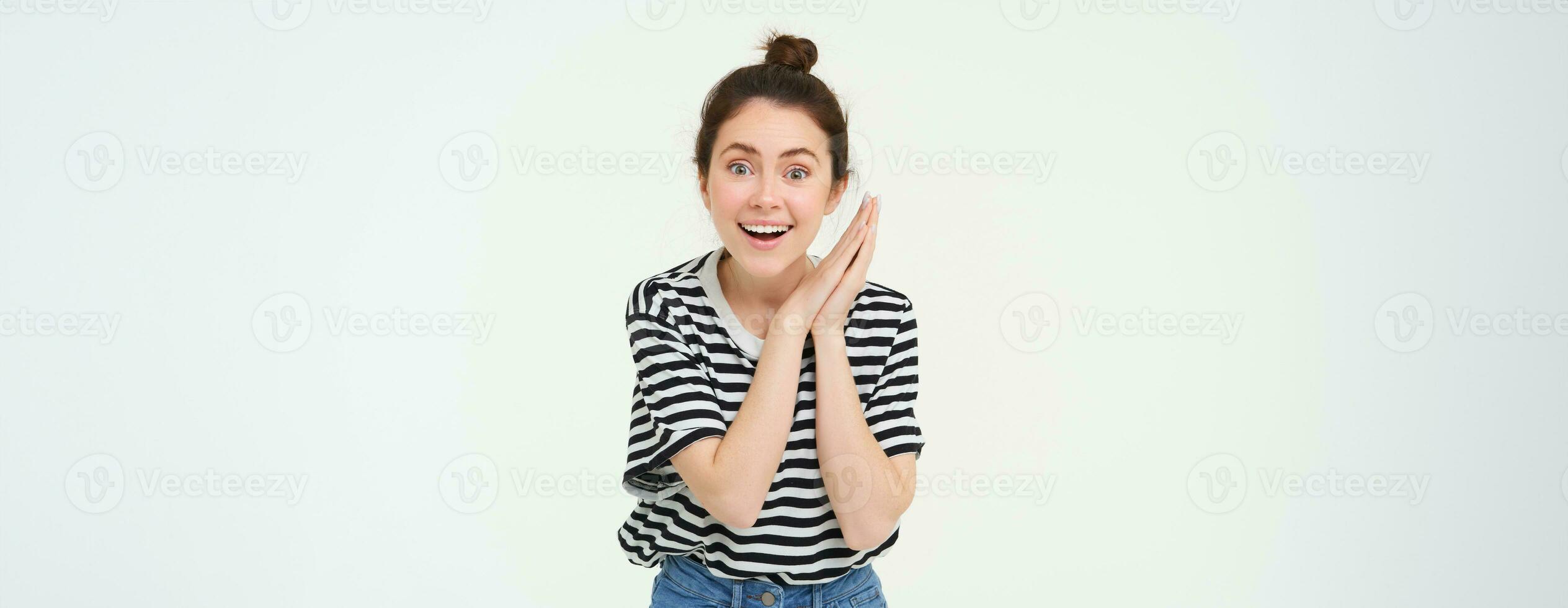 ritratto di stupito giovane donna, applaude mani e guardando a qualcosa Bellissima, isolato al di sopra di bianca sfondo foto