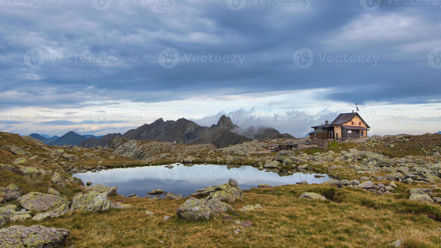 rifugio alpino vicino al laghetto di montagna foto