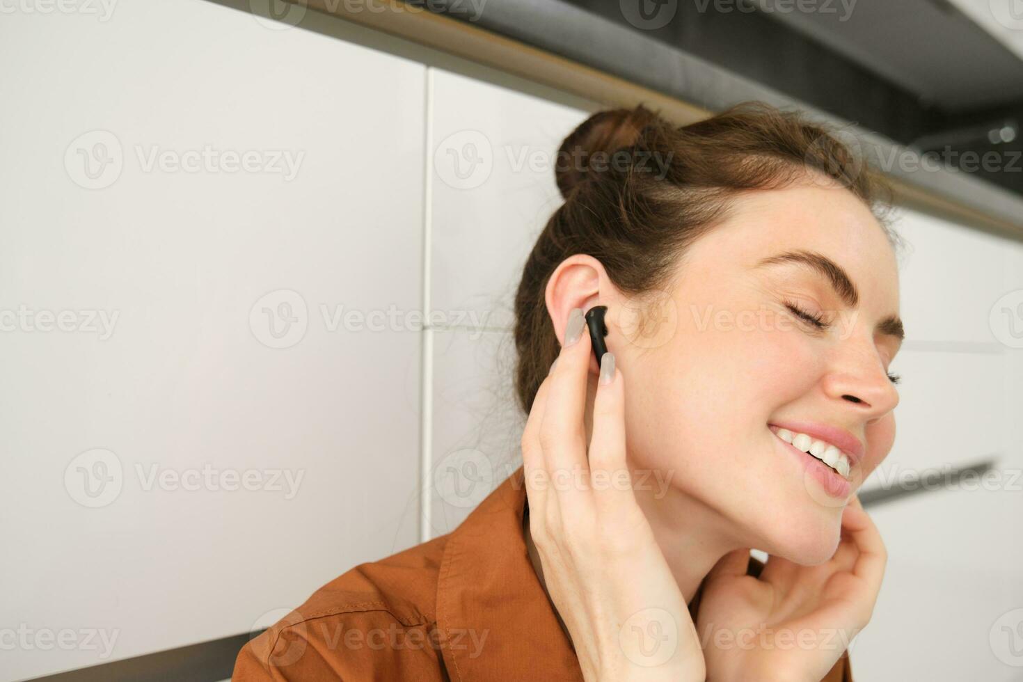 vicino su ritratto di donna sorridente a partire dal suono qualità nel sua senza fili nero auricolari, ascoltando per musica nel cuffia, lei ha lieta viso e occhi chiuso a partire dal soddisfazione foto