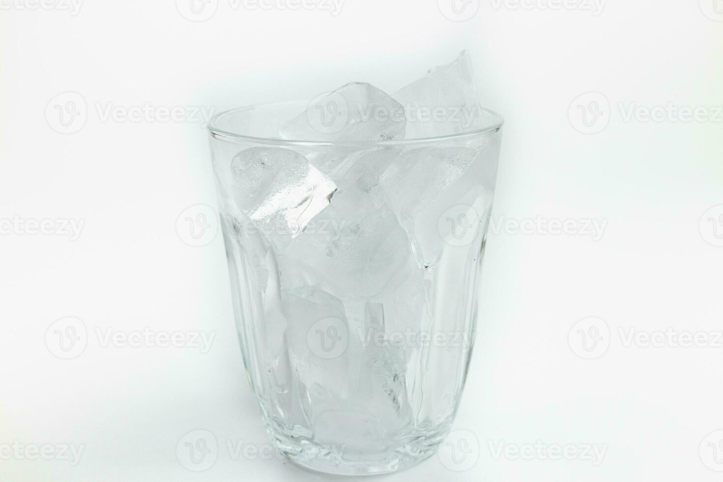ghiaccio cubi nel bicchiere isolato su bianca sfondo, superficiale profondità di campo foto