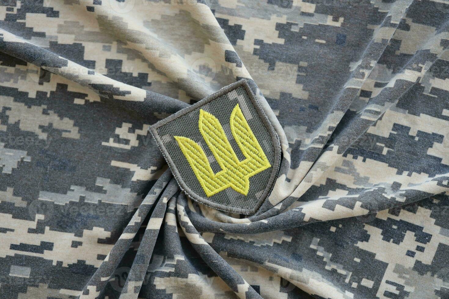 simbolo di ucraino esercito su il camuffare uniforme di un' ucraino soldato. il concetto di guerra nel Ucraina, patriottismo e proteggere il tuo nazione a partire dal occupanti foto