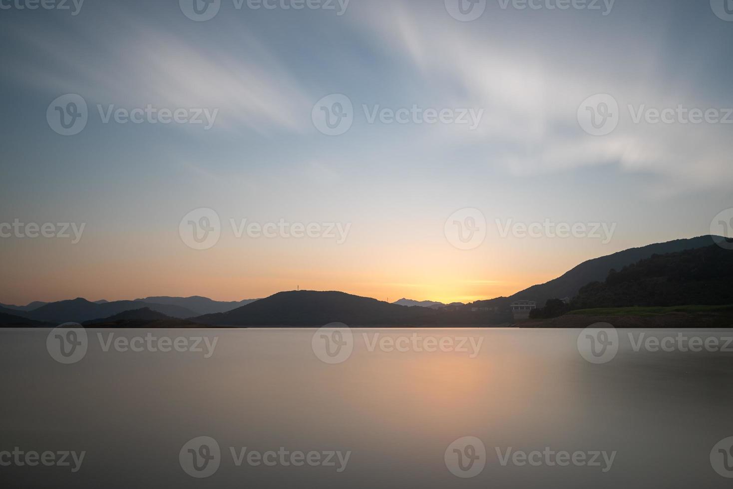 il lago serale rifletteva le montagne e il cielo su entrambi i lati foto