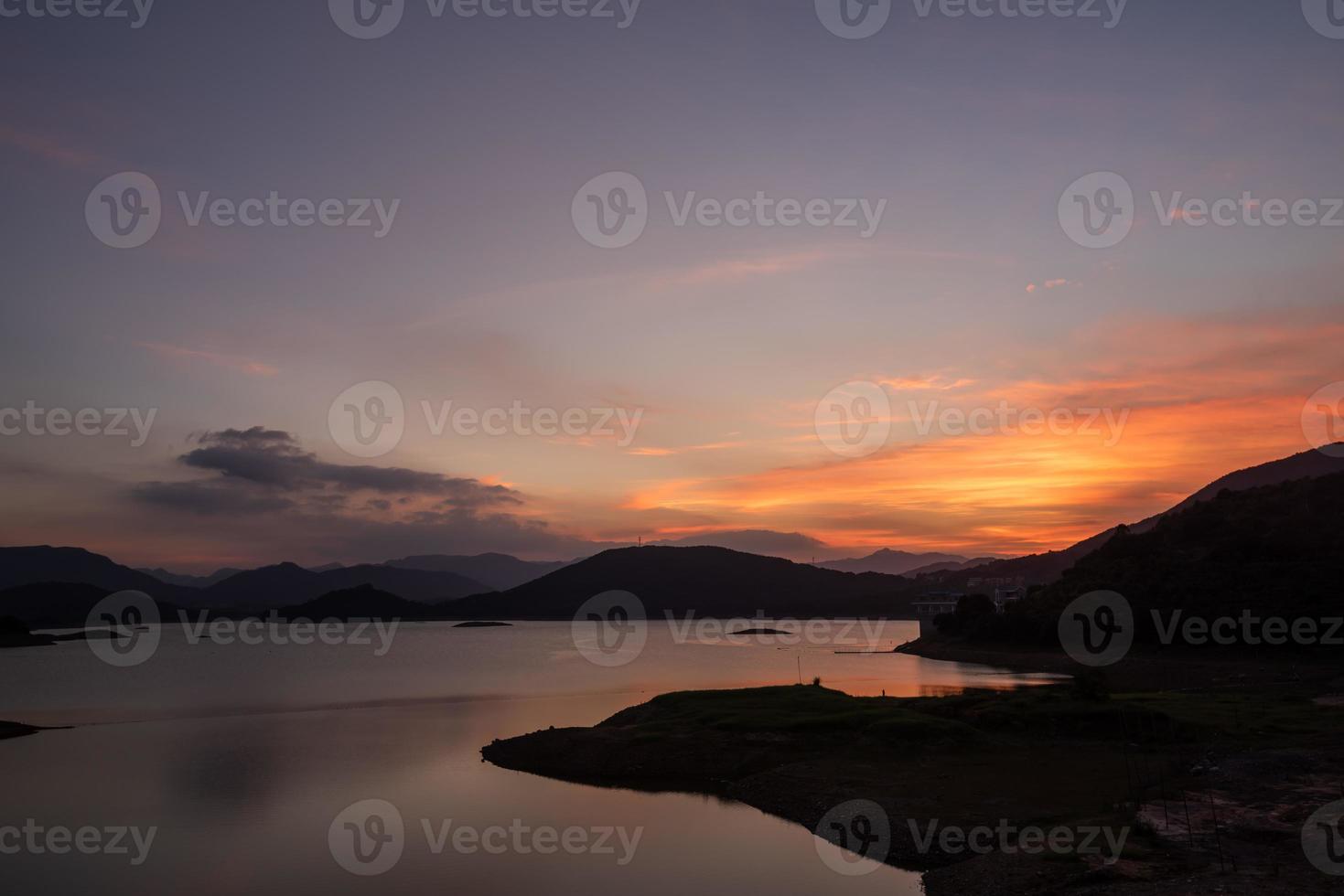 il lago serale rifletteva le montagne e il cielo su entrambi i lati foto