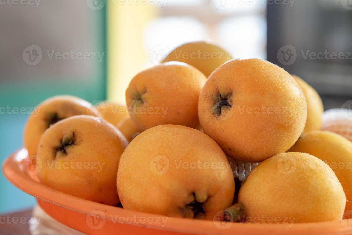 nespole gialle e grosse nel piatto foto