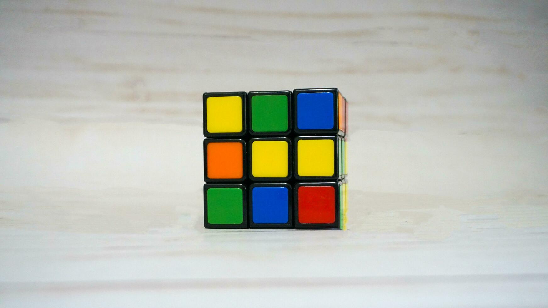 Magia cubo, di rubik cubo, su di legno tavolo sfondo. 3d combinazione puzzle. foto