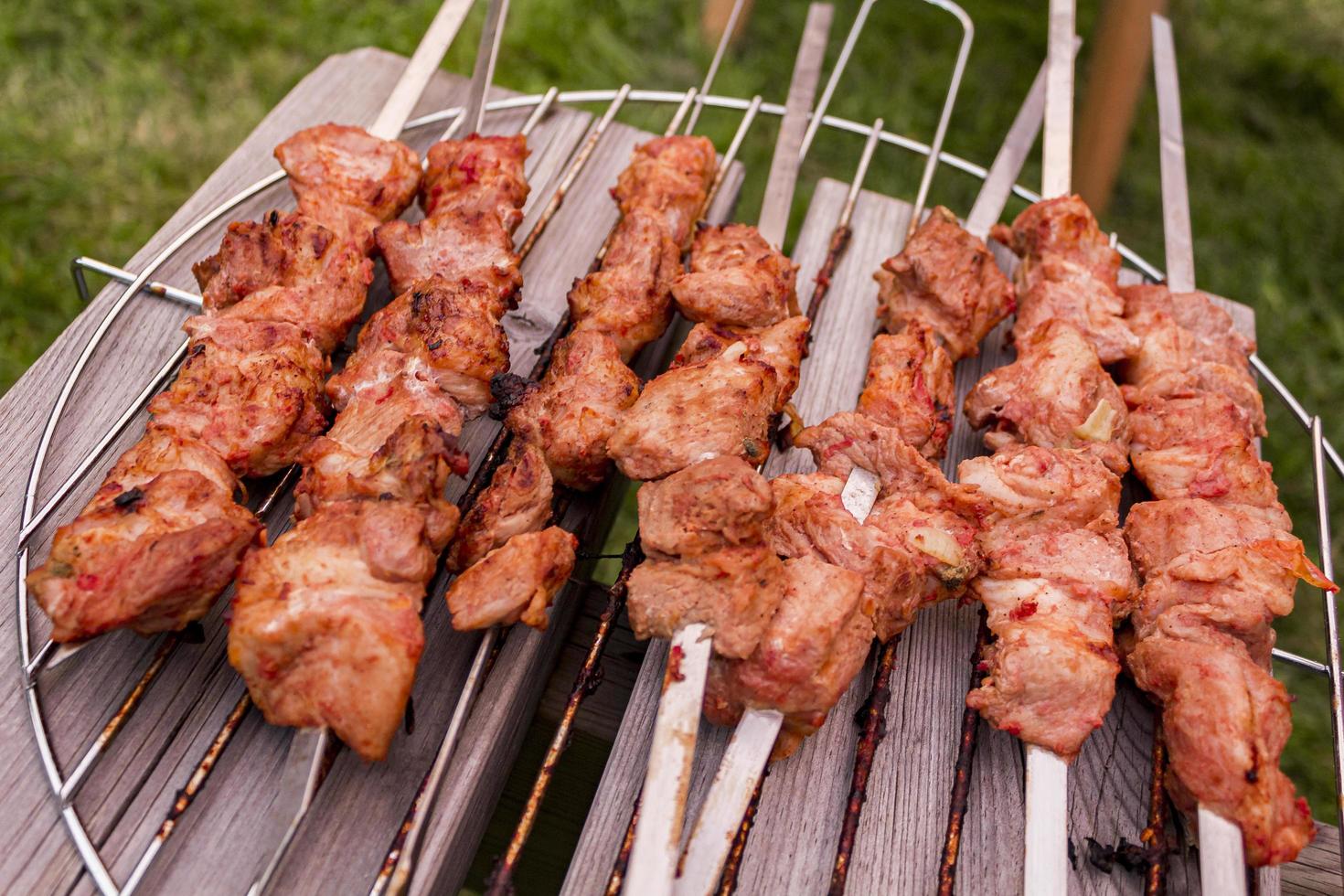 shashlik russo con spiedini su una griglia rotonda foto