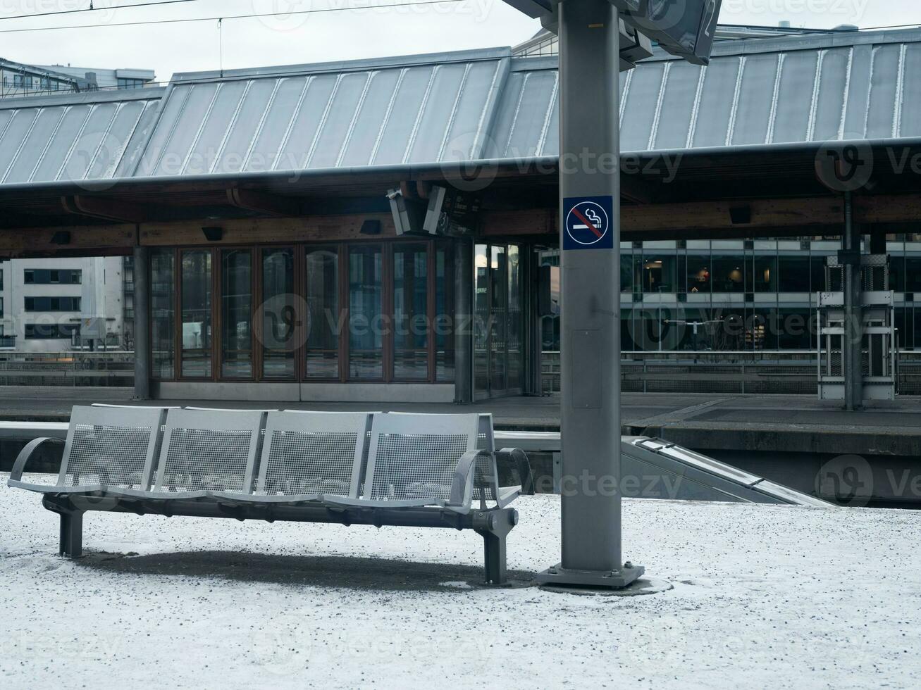 un' leggero neve coperture il terra a un vuoto treno stazione. foto