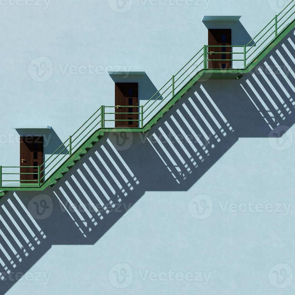 scale di ferro verde accanto a un edificio alto. concetto di luce e ombra. foto