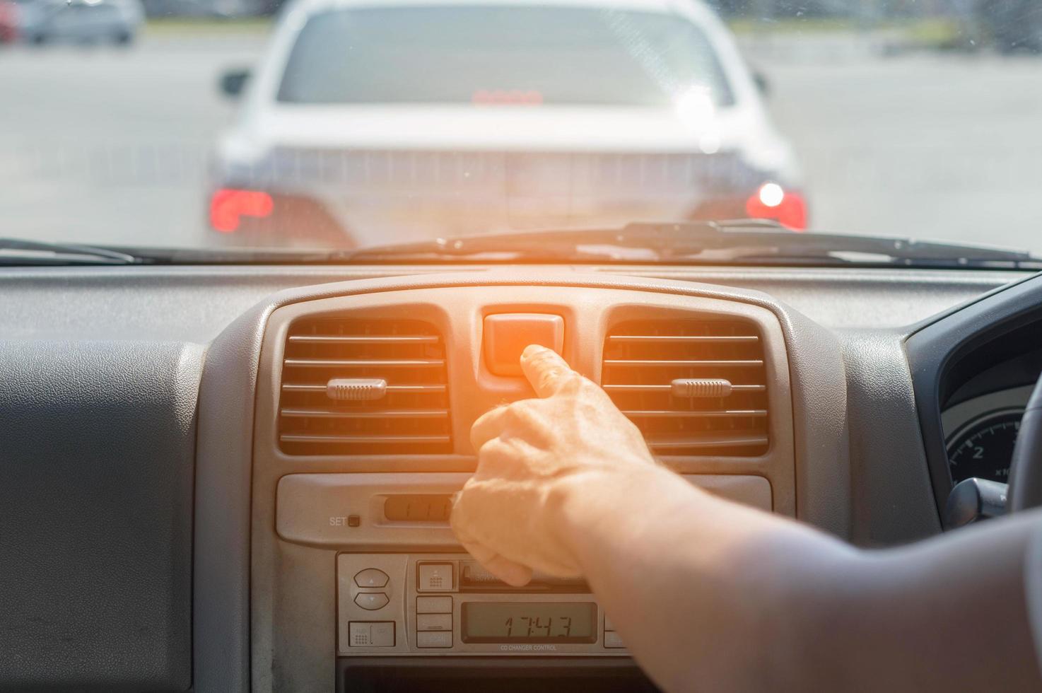 dito che colpisce il pulsante della luce di emergenza dell'auto foto