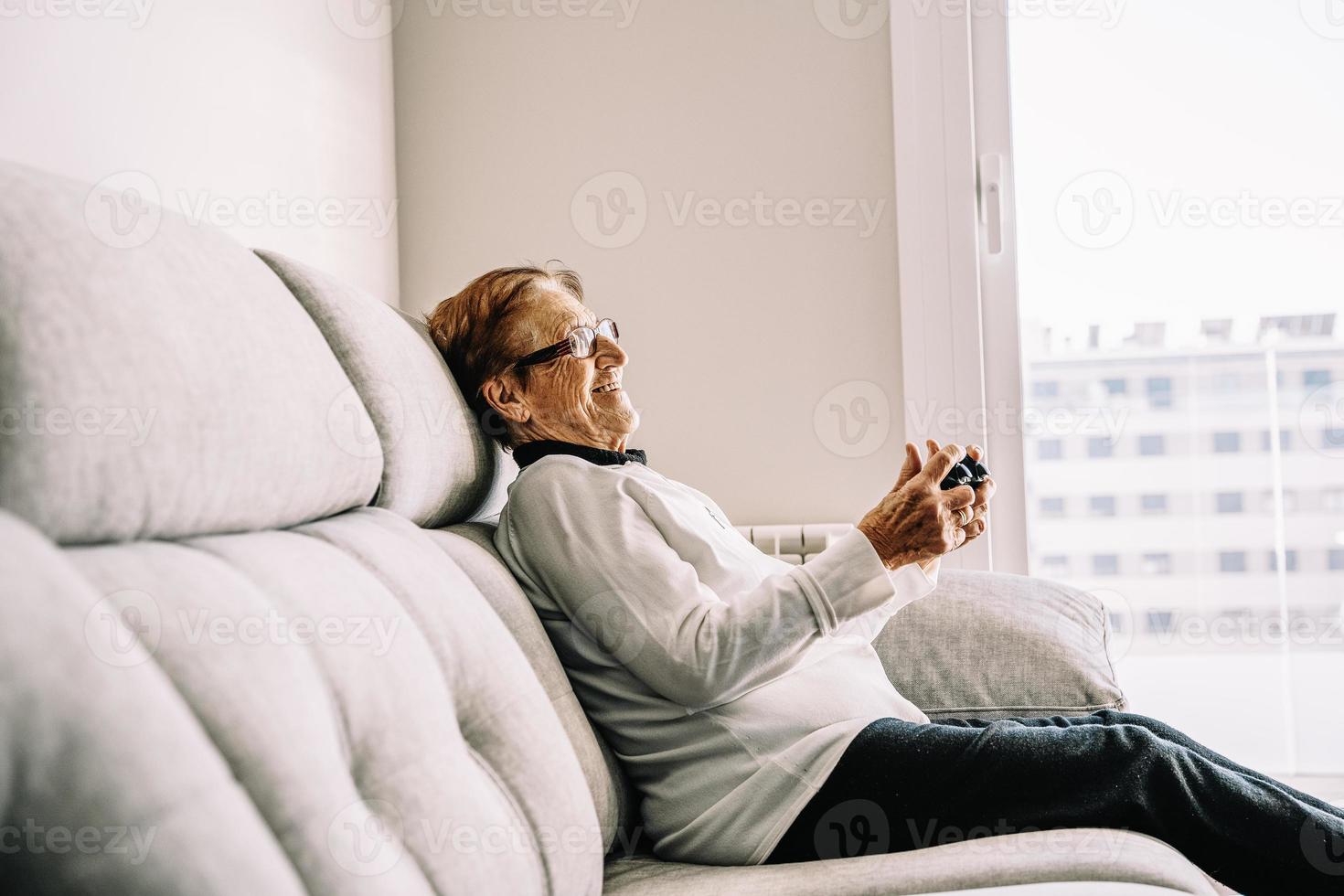 contenuto donna anziana con console che gioca al videogioco foto