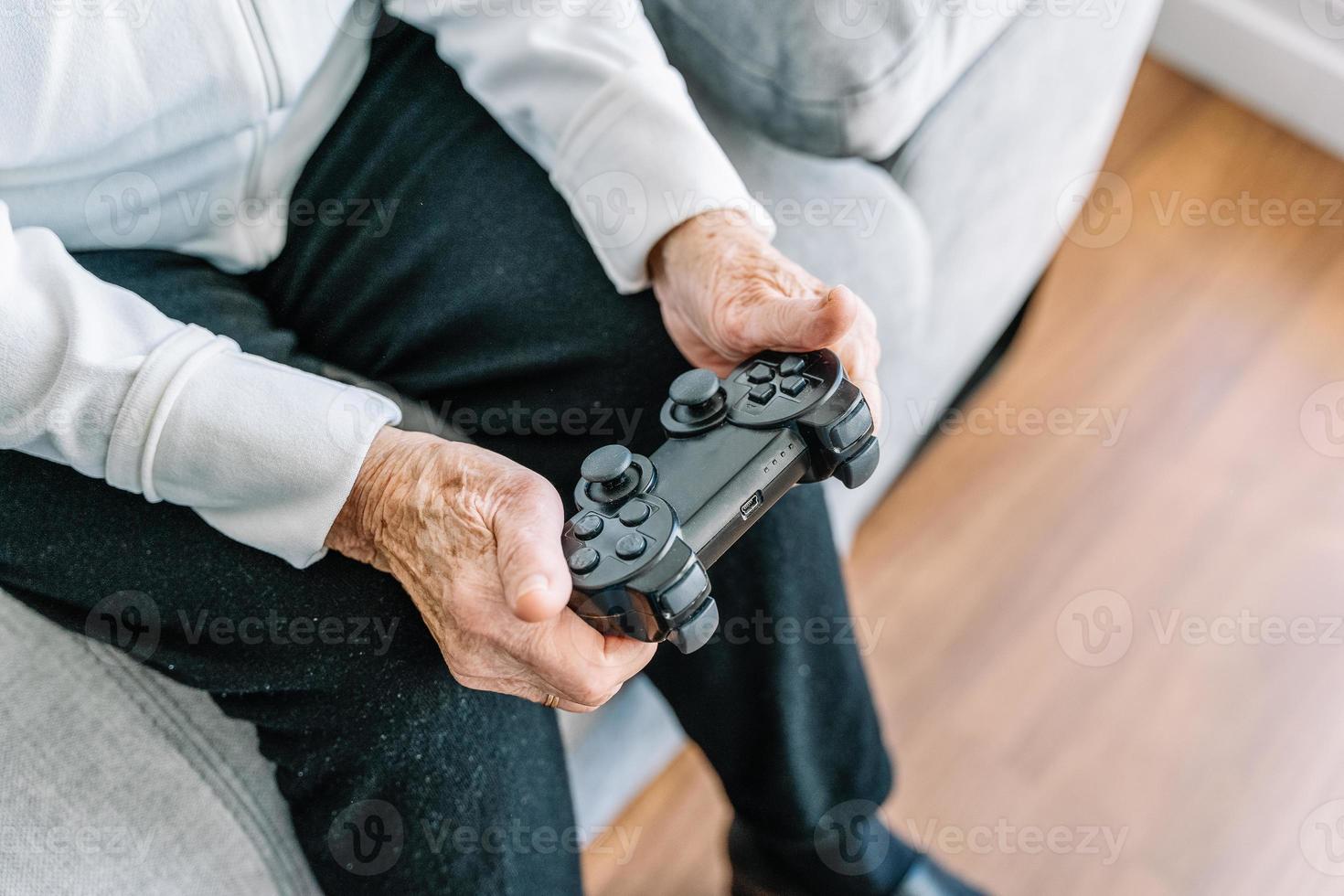 ritaglia una donna anziana con gamepad a casa foto