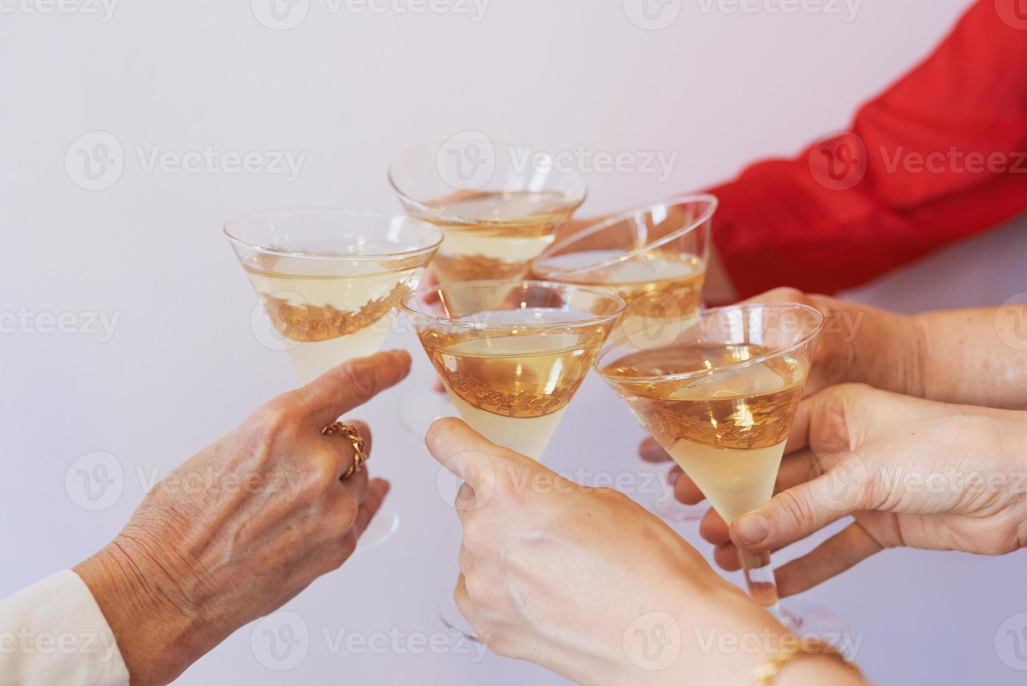 capodanno che celebra le mani con bicchieri di spumante bianco. natale, famiglia, amici, festeggiare, concetto di capodanno foto