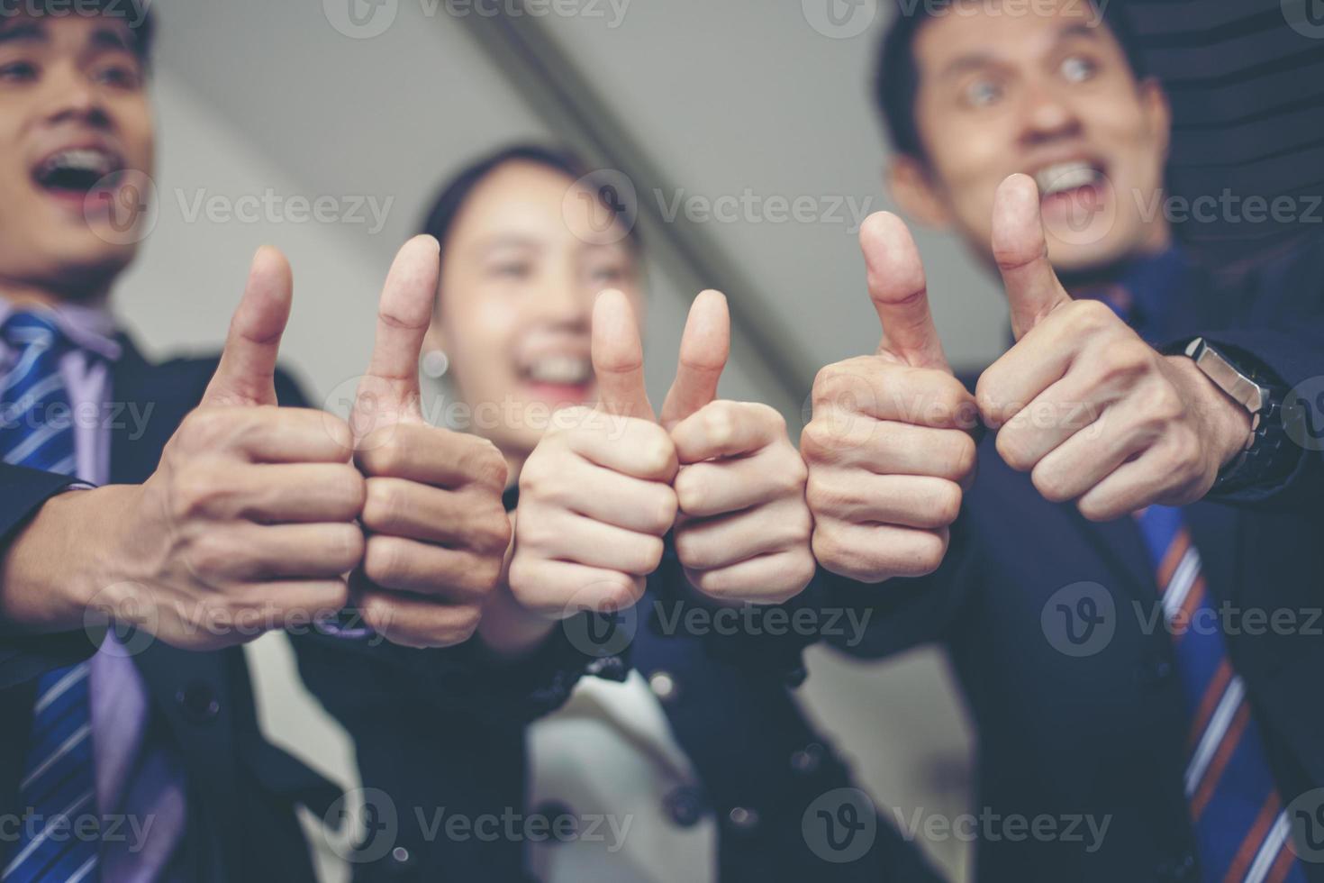 sorridente felice uomo d'affari e imprenditrici che celebrano il successo con il braccio alzato e mostrano il pollice in su concept foto