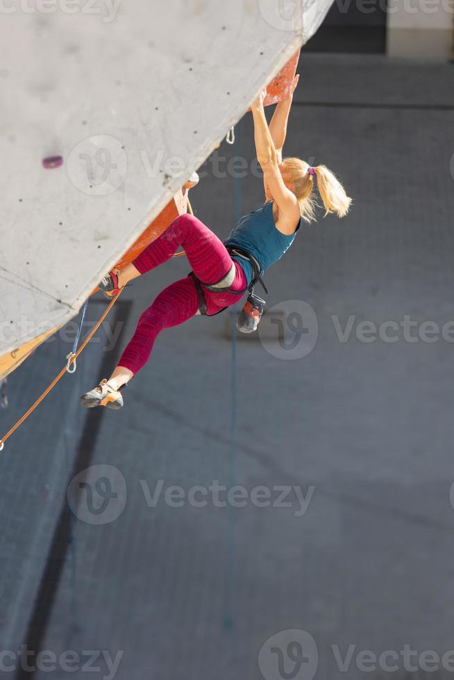 la ragazza è impegnata nell'arrampicata su roccia foto