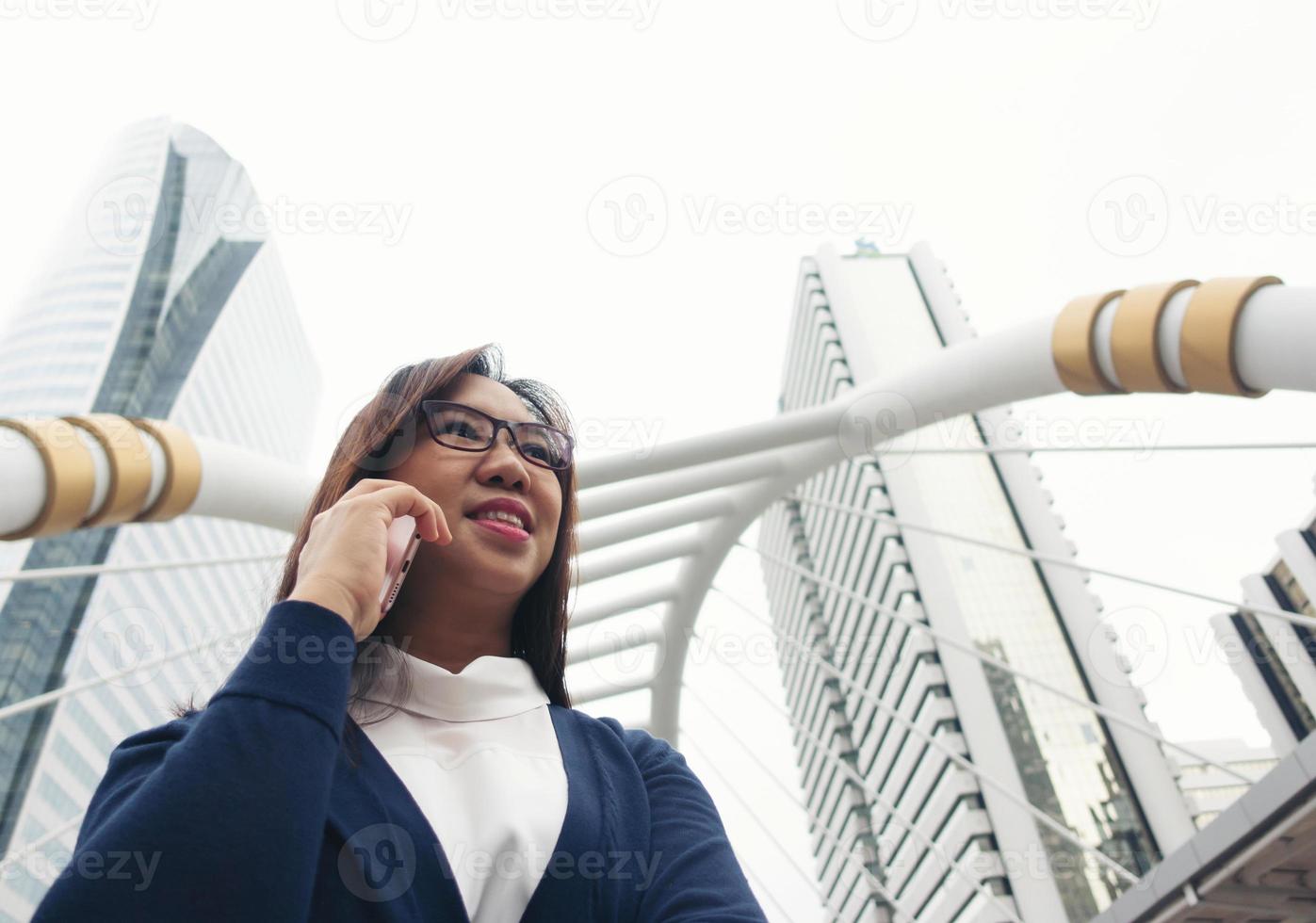 donna che cammina all'aperto e parla al cellulare foto