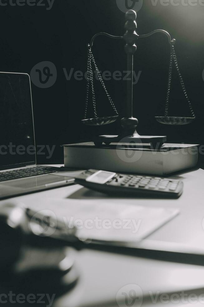 Immagine di giudici martello, bilancia signora di giustizia, legge prenotare, il computer portatile computer e contrarre documenti con penna concetto di legge e giustizia. foto