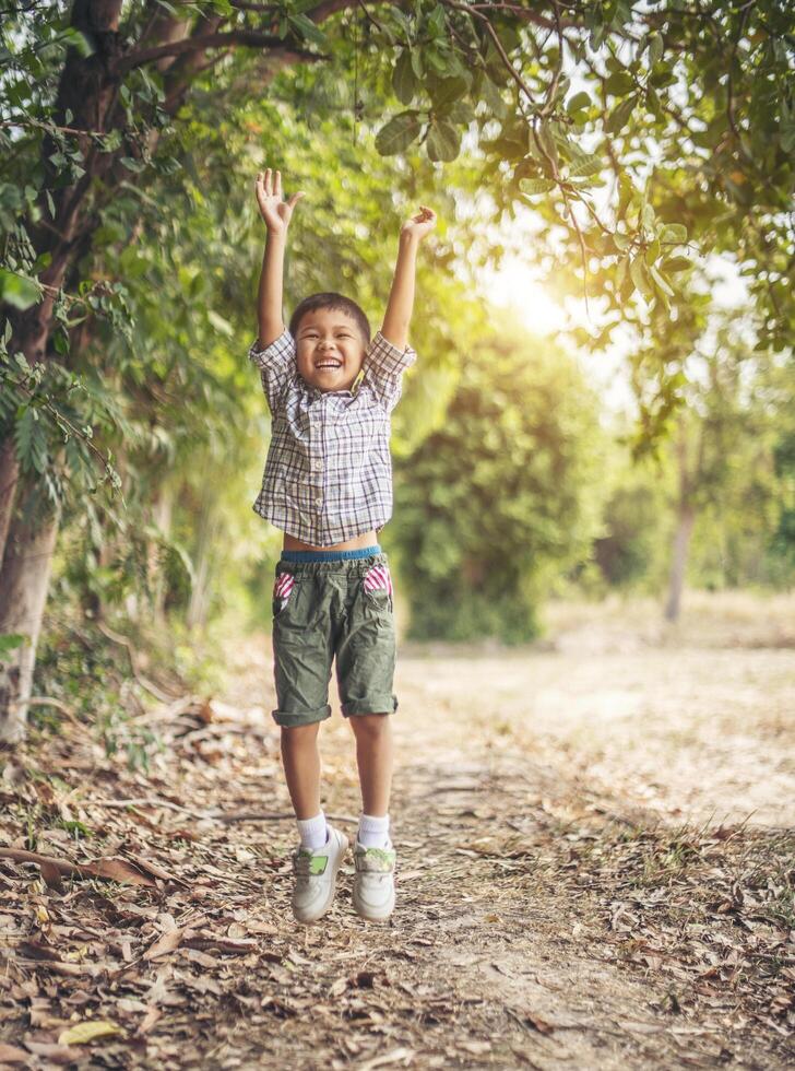 ragazzo felice che gioca da solo nel parco foto