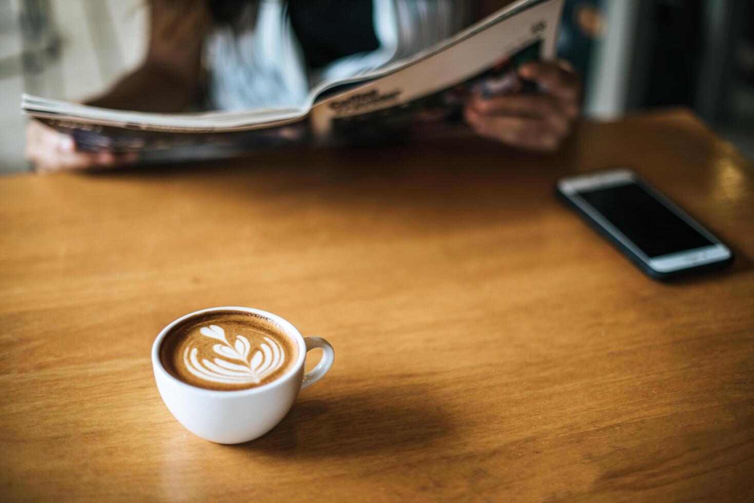 latte art nella tazza di caffè sul tavolino del bar foto