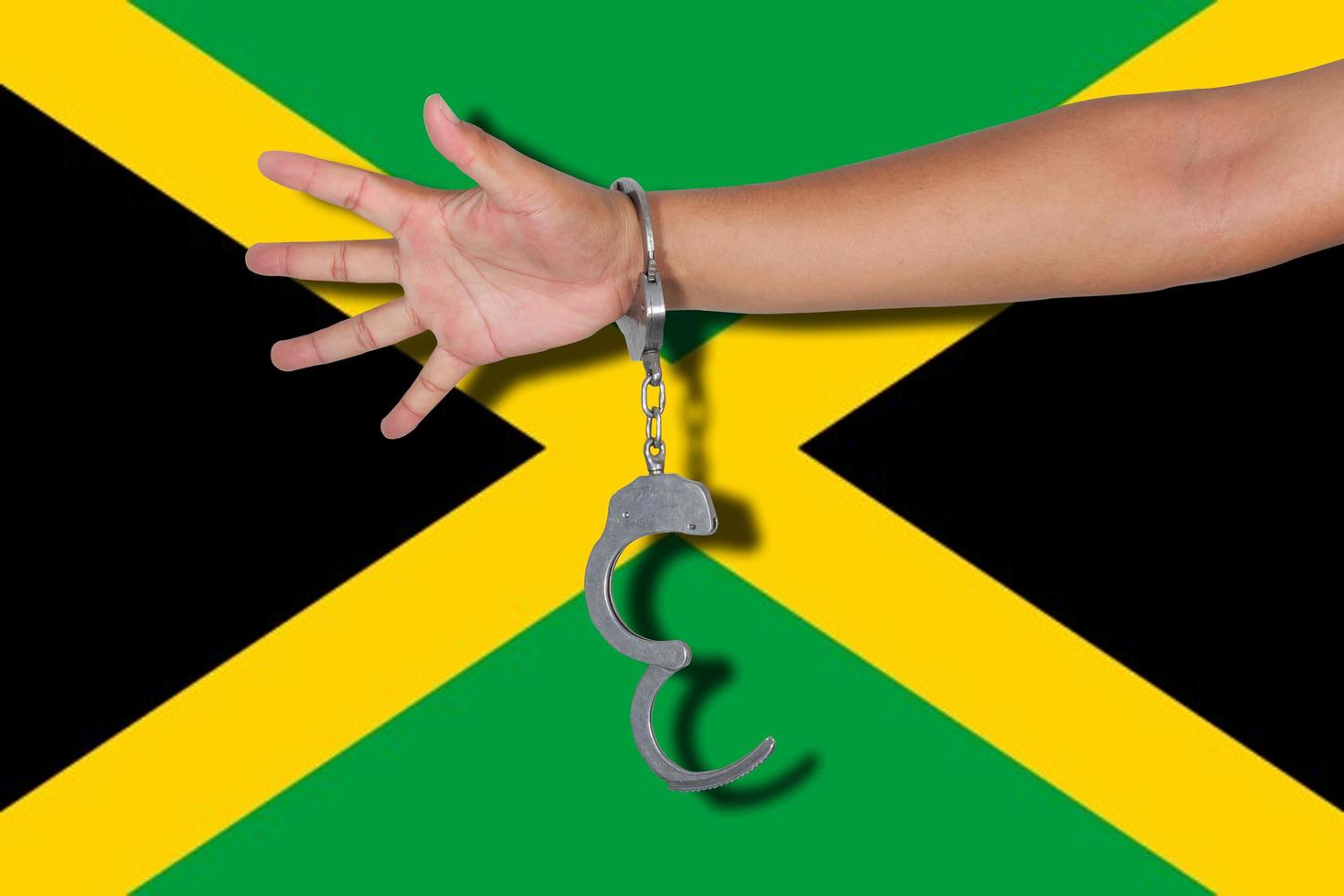 manette con la mano sulla bandiera della Giamaica foto