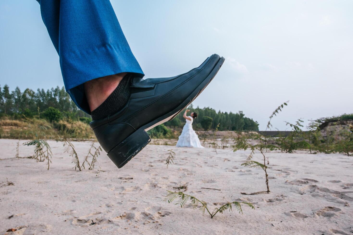 divertente sposa asiatica e sposo caucasico che pubblicano uno scherzo con i piedi in cima foto