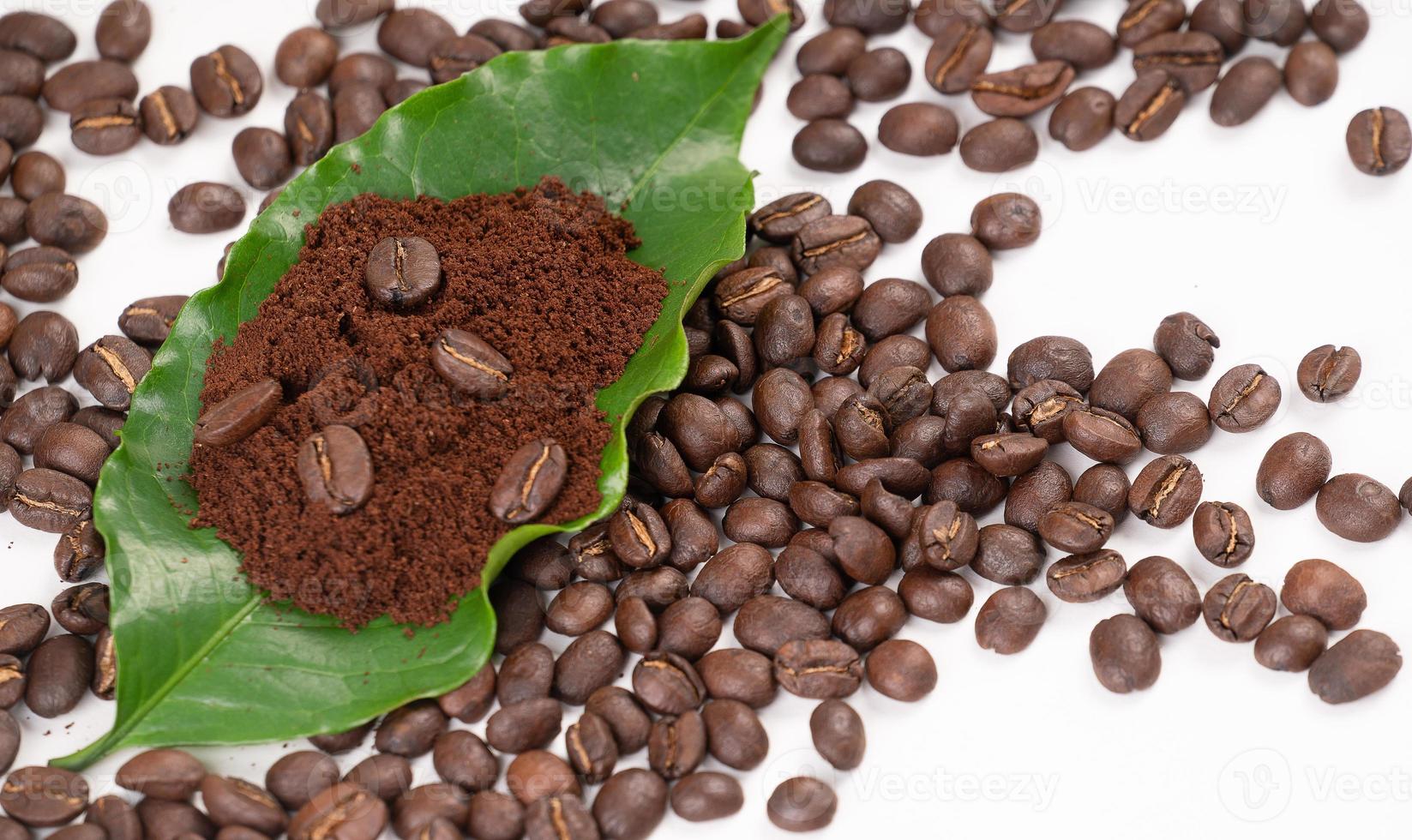 chicco di caffè tostato con foglie su sfondo bianco foto