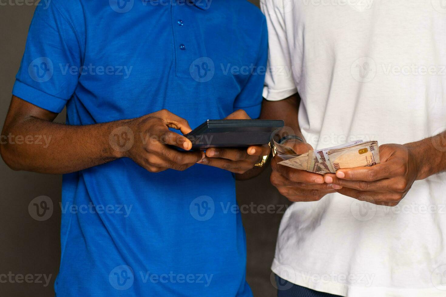 uomo conteggio i soldi e un altro utilizzando un' calcolatrice foto