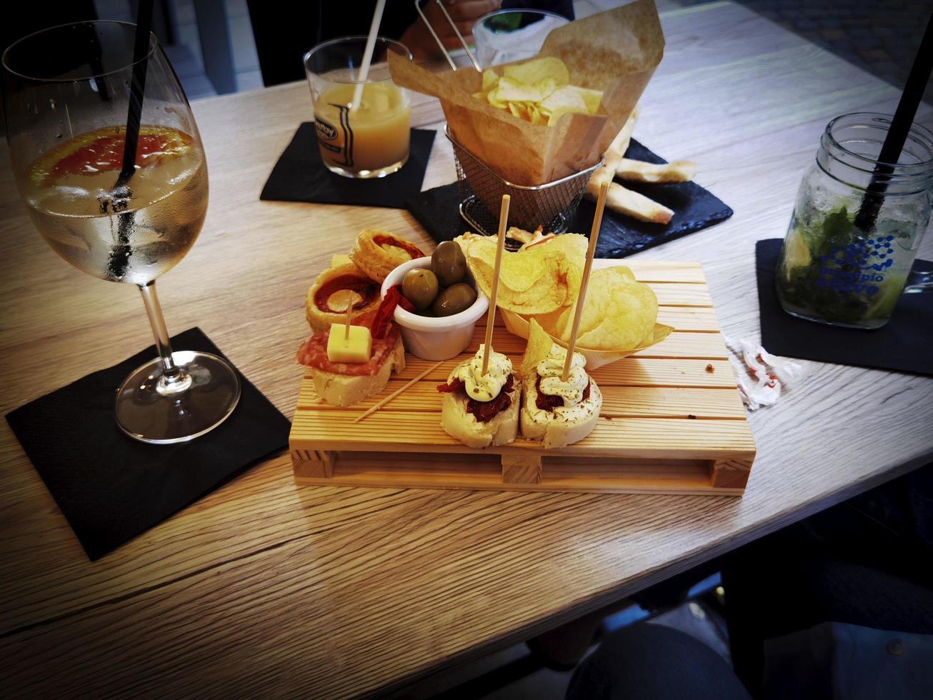 aperitivo al tavolo con bevande e snack da mangiare e gustare in una giornata estiva sulla riviera ligure foto