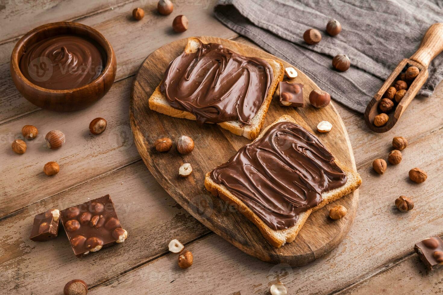 tavola di pane con cioccolato incolla e Nocciole su di legno sfondo foto