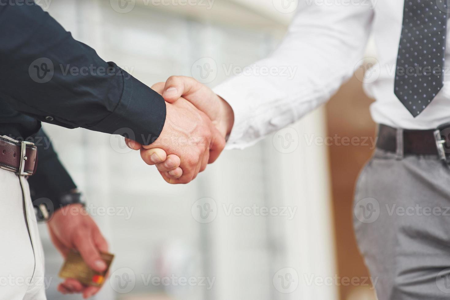 stretta di mano di due uomini. contatti commerciali di successo dopo un buon affare foto