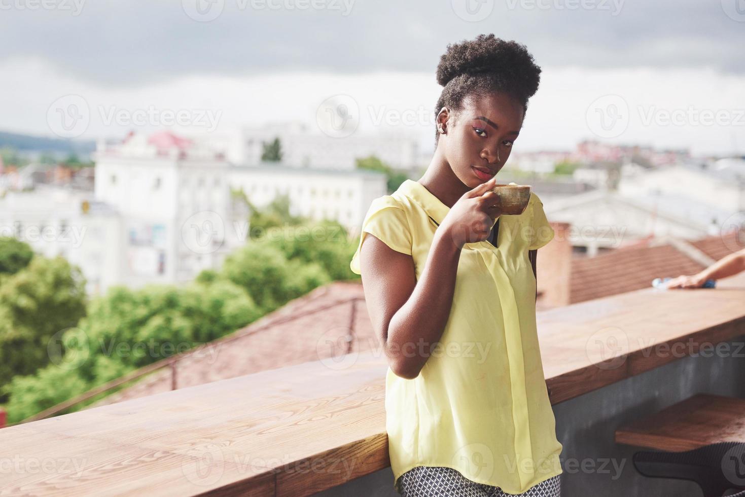 bella giovane donna d'affari afroamericana che beve caffè in un bar. bellissimo posto accogliente foto