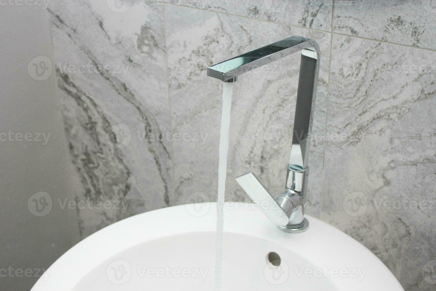 moderno rubinetto con in esecuzione acqua nel il bagno, azione foto