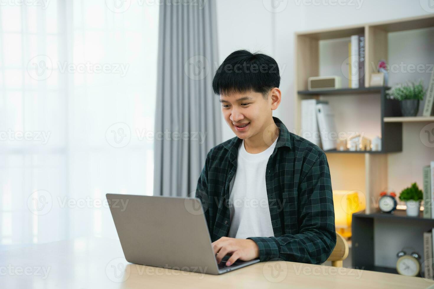 inteligente asiatico uomo con bretelle sorridente Lavorando con computer il computer portatile. concetto opera modulo casa, restare a casa. libero professionista vita stile, nuovo normale sociale distanziamento stile di vita. opera modulo dovunque concetto. foto