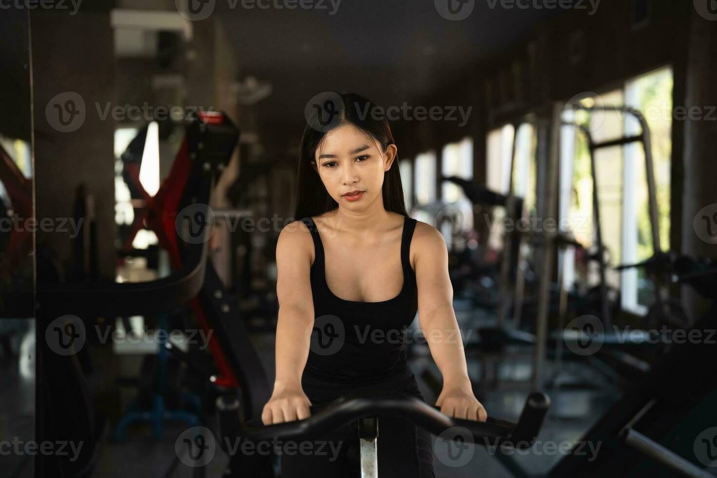 asiatico sportiva esercizio su un' bicicletta nel il palestra, determinazione per cardio perdere il peso, fa sua sano. esercizio bicicletta donna fitness sport concetto. foto