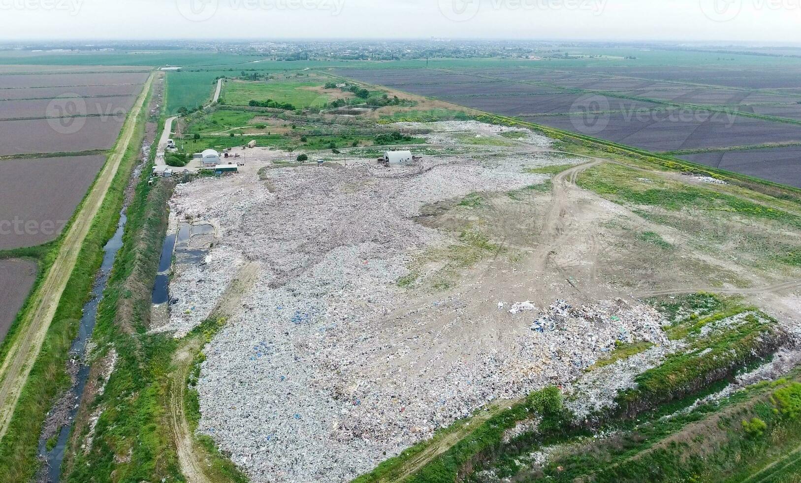 spazzatura cumulo di rifiuti con mucchi di spazzatura e trattamento strutture. discarica di spazzatura al di fuori il villaggio foto