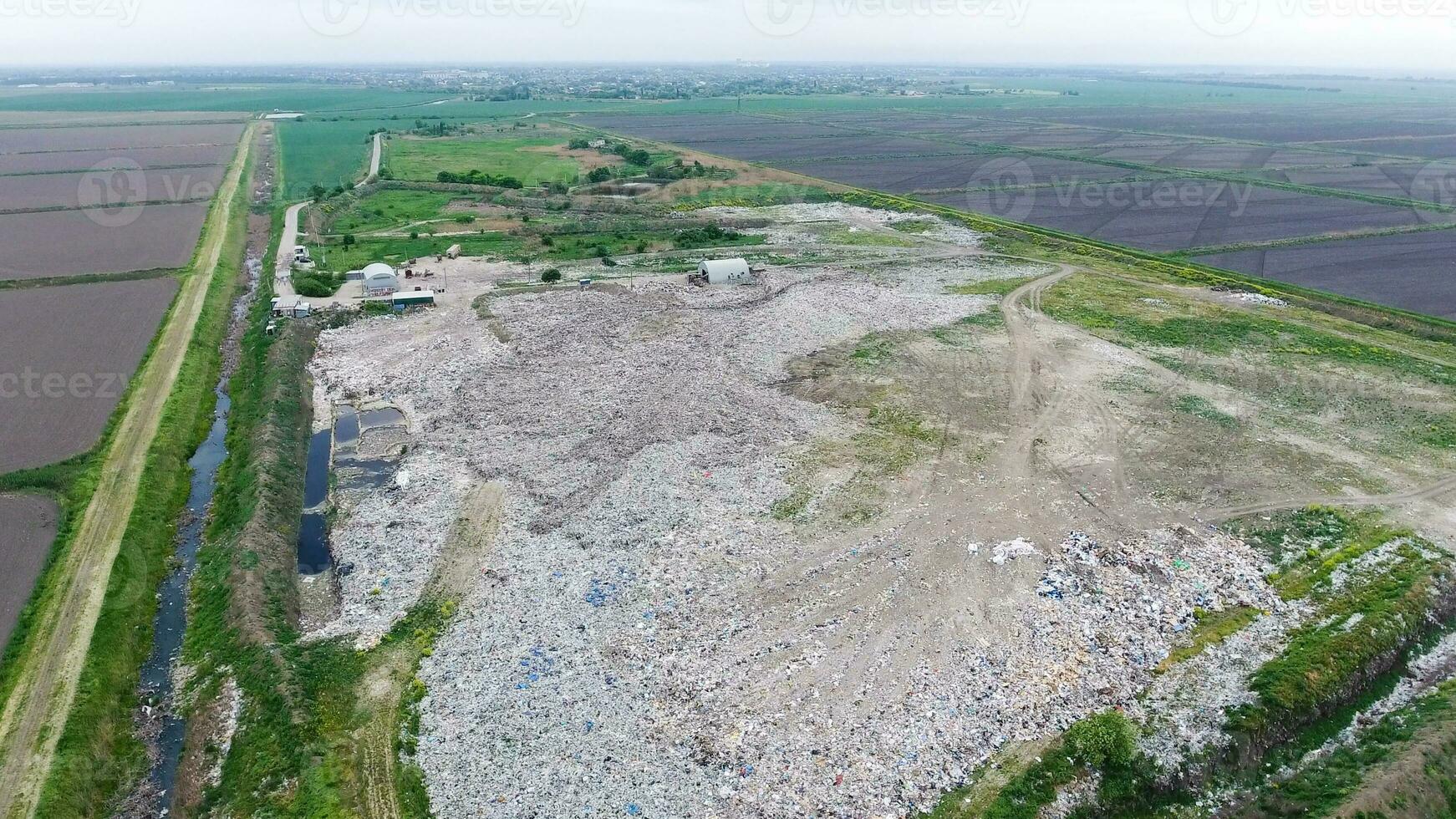 spazzatura cumulo di rifiuti con mucchi di spazzatura e trattamento strutture. discarica di spazzatura al di fuori il villaggio foto