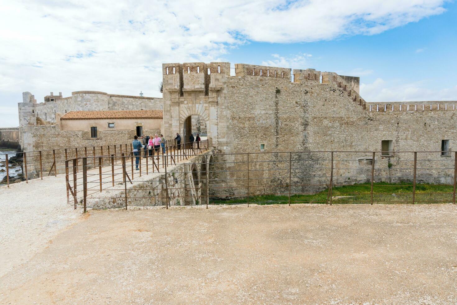 Siracusa, italia-maggio 9, 2022 persone visitare il famoso maniaco castello su il isola di ortigia nel siracusa durante un' soleggiato giorno foto