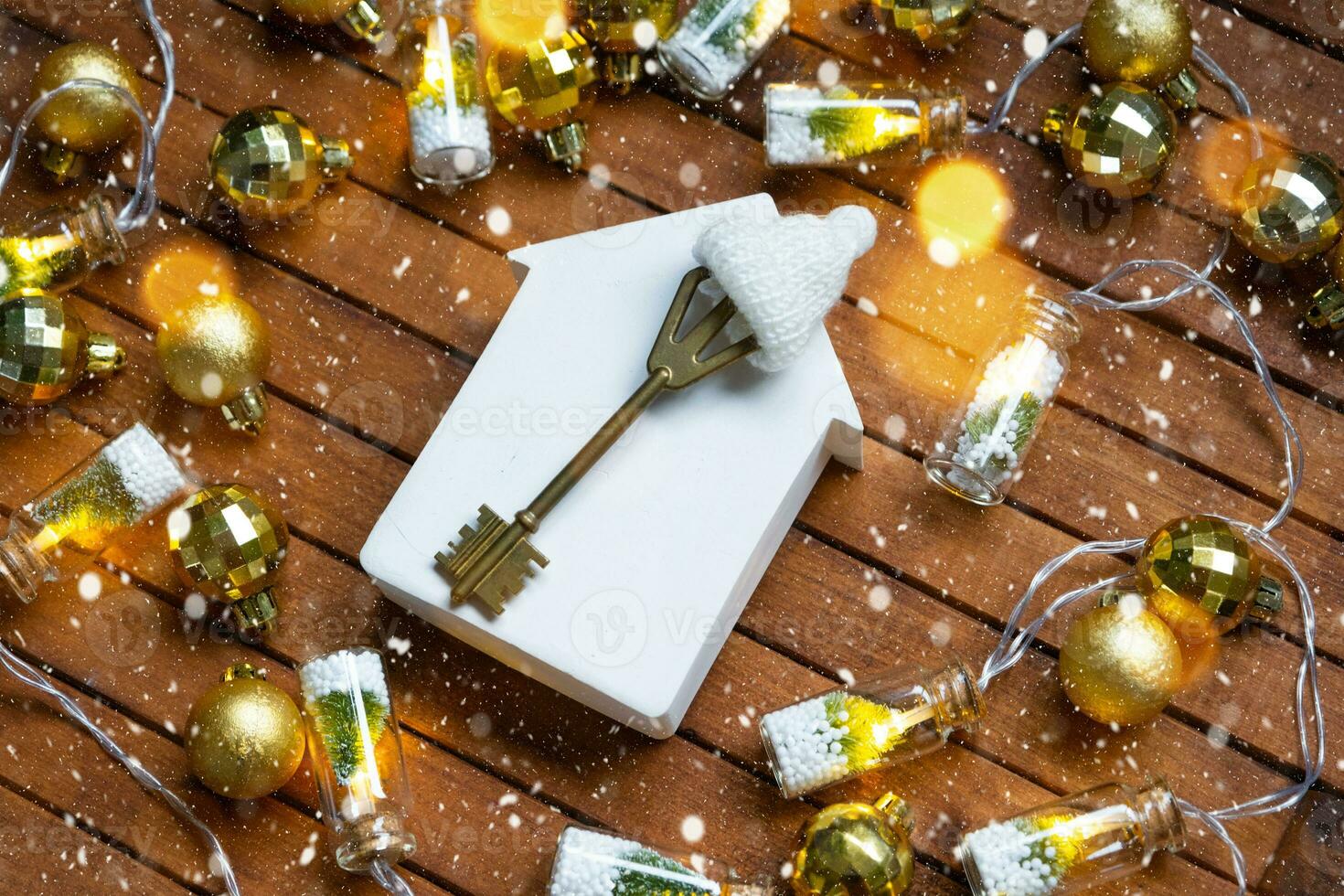 chiave per Casa con un' portachiavi minuscolo casa su di legno sfondo con Natale arredamento disposizione. regalo per nuovo anno, Natale. costruzione, progetto, in movimento per nuovo Casa, mutuo, affitto e Acquista vero tenuta foto