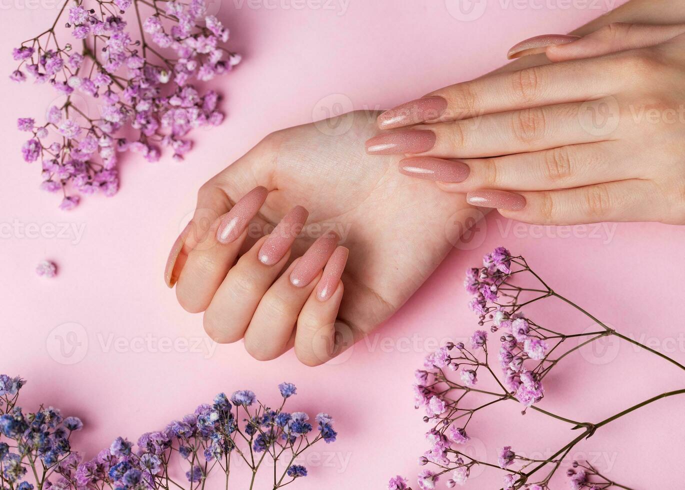 femmina mani con rosa chiodo design hold gypsophila fiori. foto