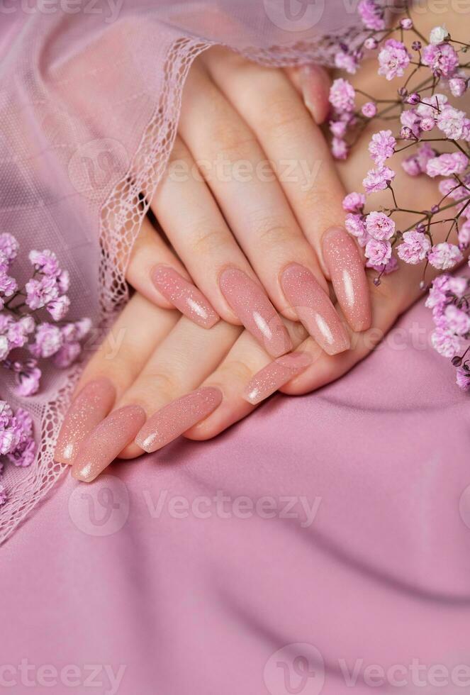 femmina mani con rosa chiodo design hold gypsophila fiori. foto