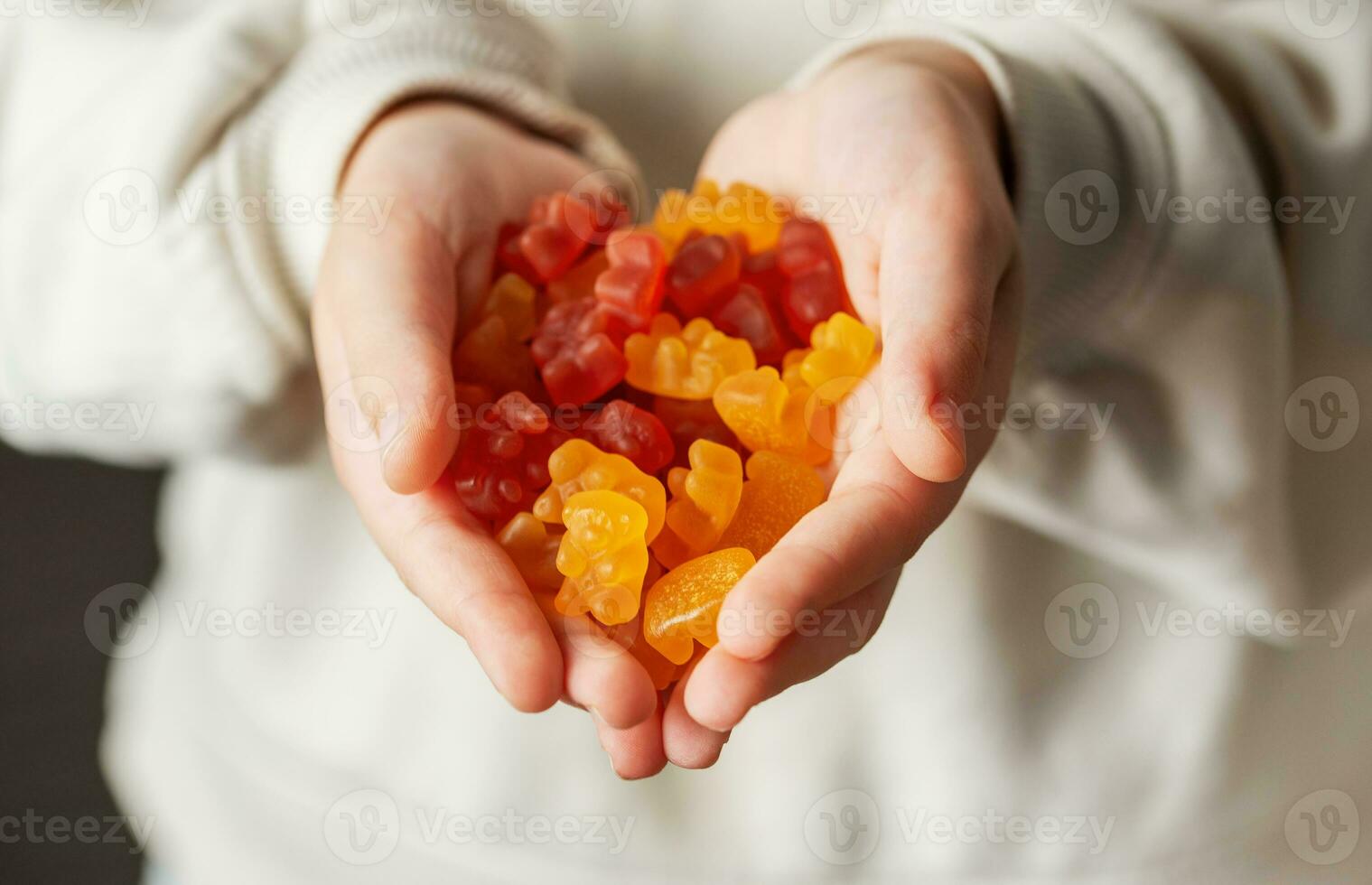 un' ragazza detiene un' gommoso orso vitamine nel sua mani foto