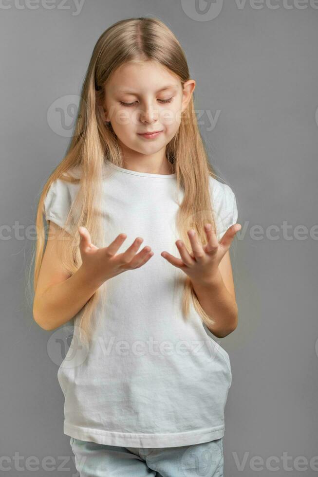 carino poco ragazza guardare a sua mani foto