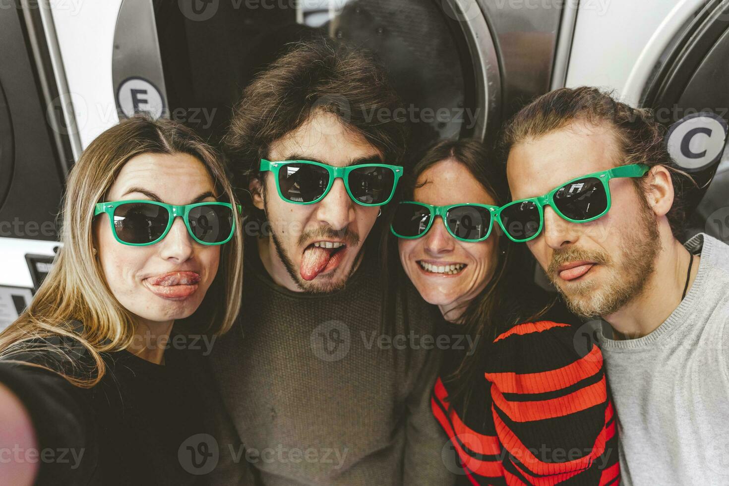 gruppo di giovane amici indossare verde occhiali da sole avendo divertimento assunzione un' autoscatto foto