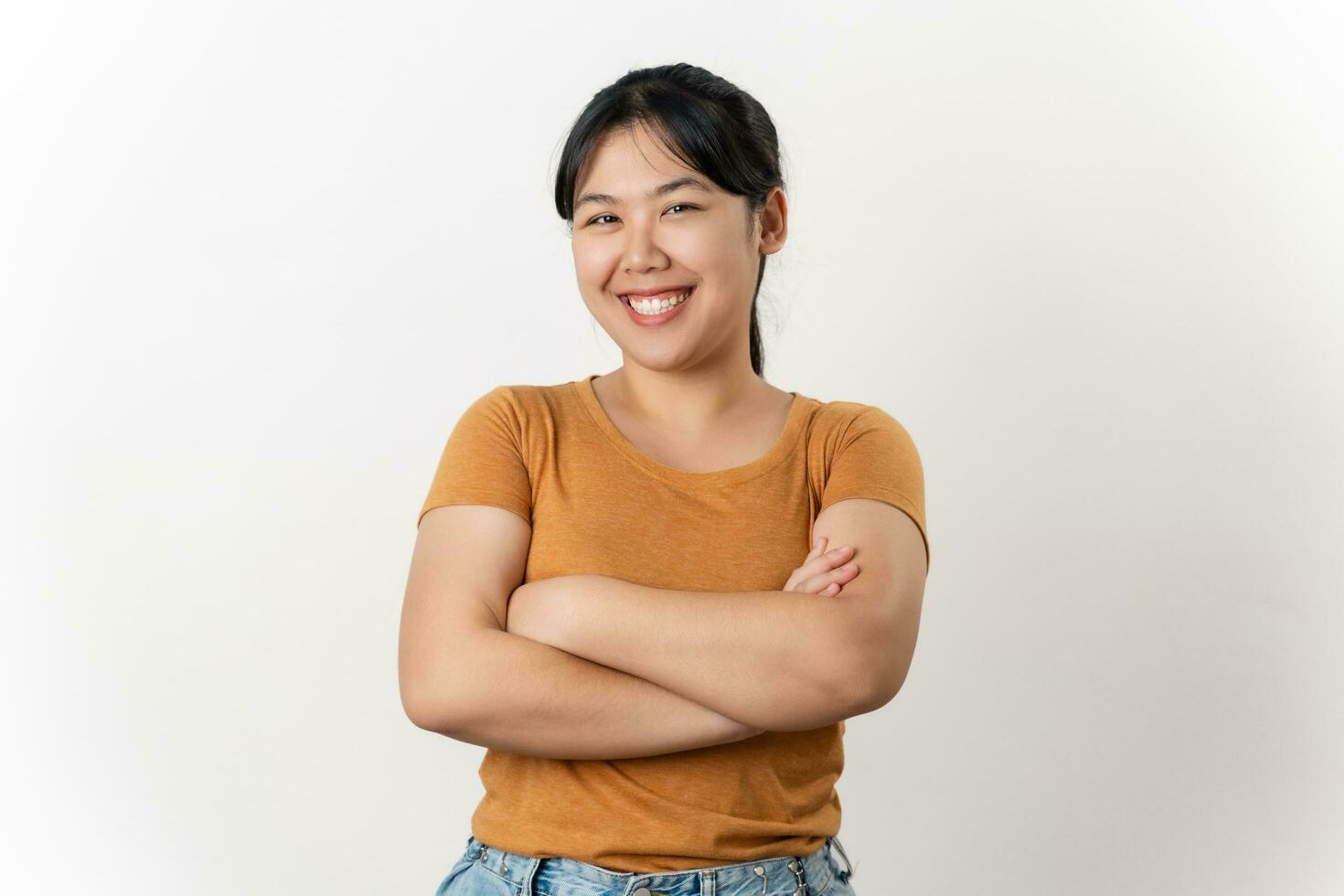 il bella e contento asiatico giovane donna è sorridente con fiducia in piedi su un' bianca sfondo. foto