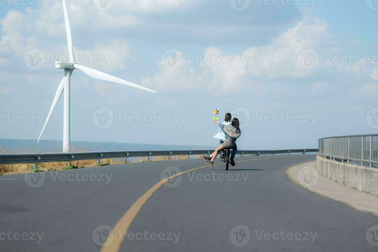 indietro Visualizza di un' giovane donna equitazione un' bicicletta con sua fidanzato su il strada foto