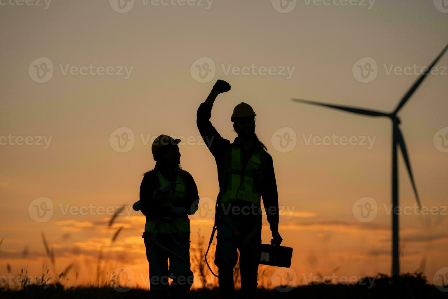 silhouette di ingegnere nel caricare di vento energia contro un' sfondo di vento turbine. foto