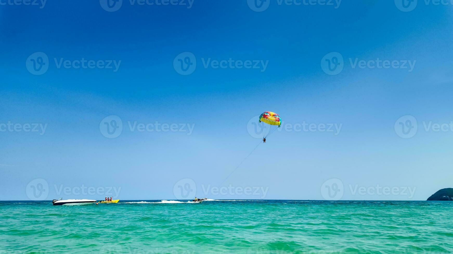 illuminata dal sole parasailing avventura al di sopra di azzurro mari foto