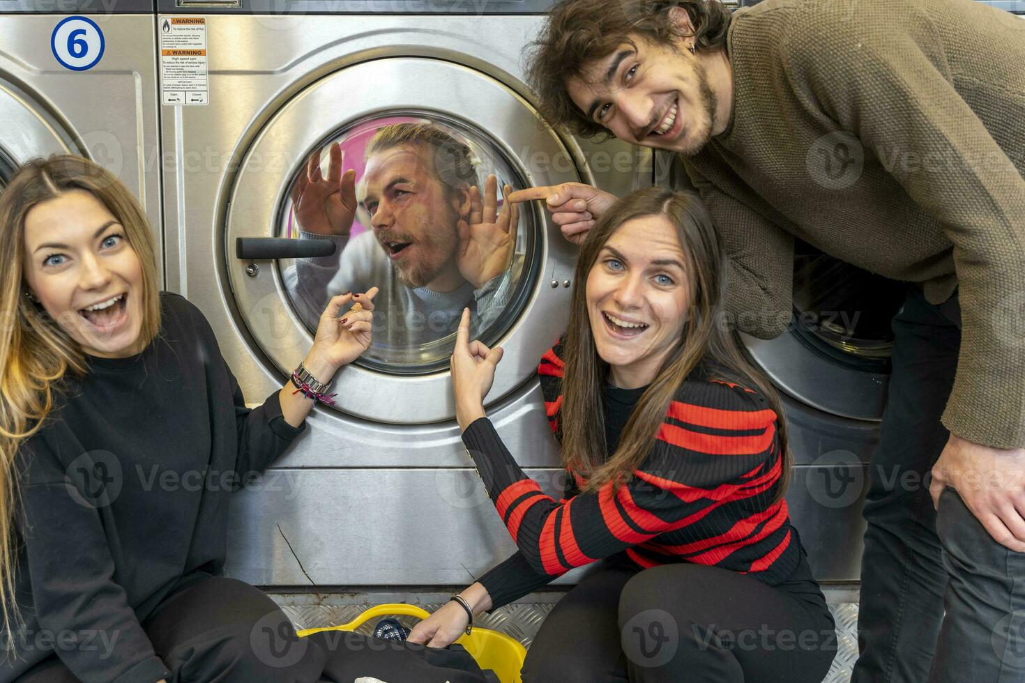 gruppo di amici nel il lavanderia camera avendo divertimento foto